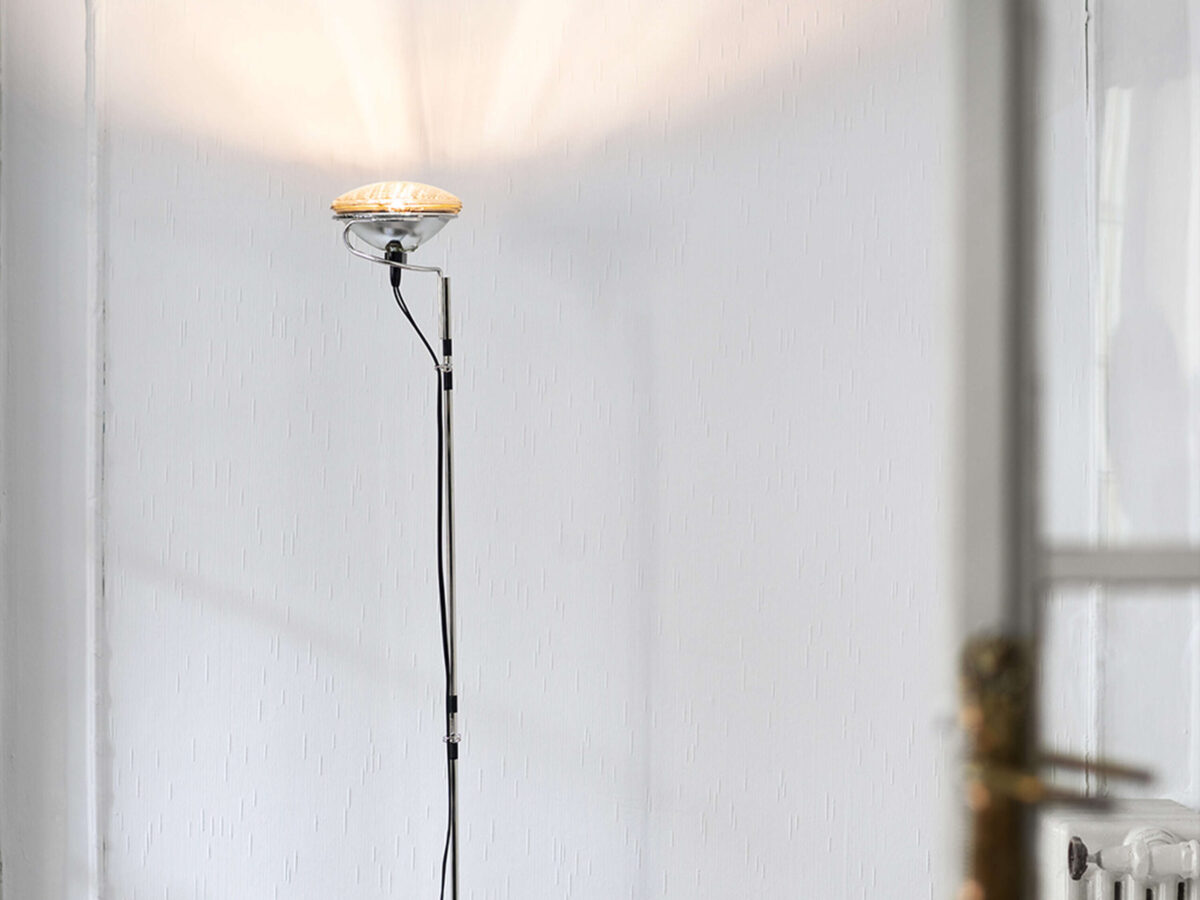 Tall lamp in matte black with angled steel base, retromodern niche housing LED bulb and integrated cable dimmer switch.