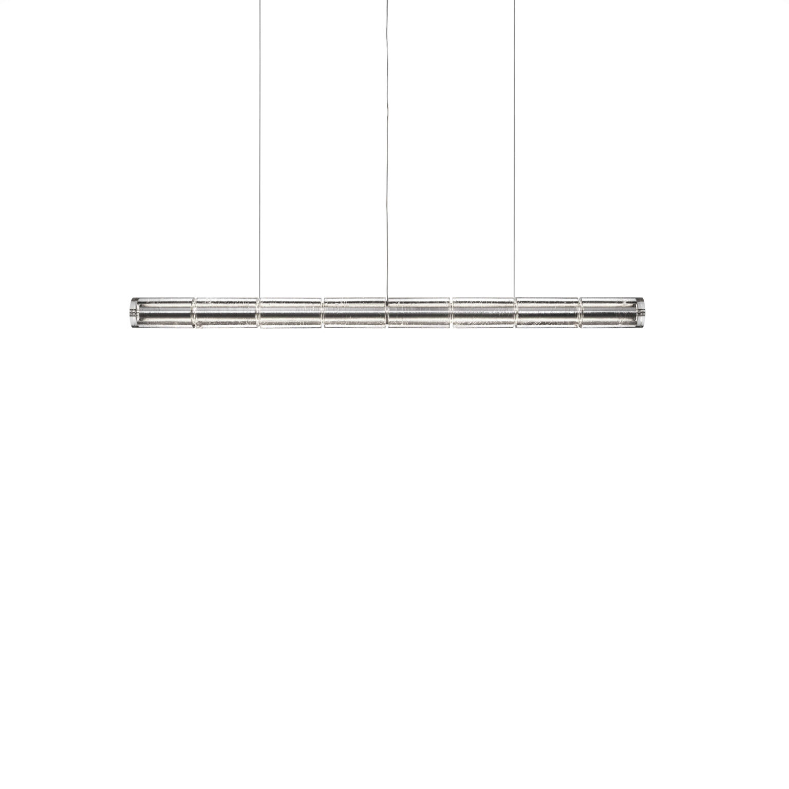 Luce Orizzontale S1 pendant: elongated bar of interconnected cylindrical glass modules suspended by slim clear cables above a dining table.