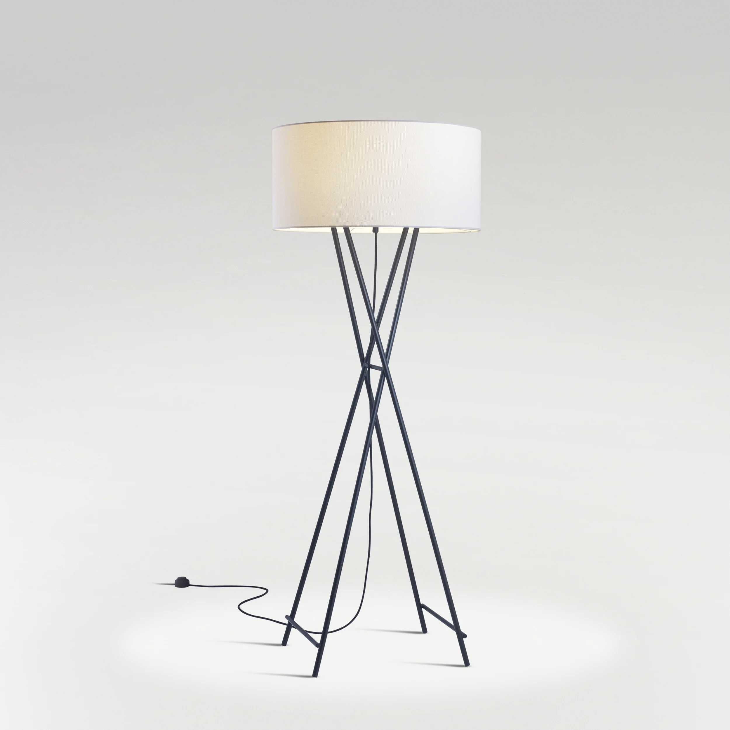 “Cala Metal by Marset floor lamp – sleek black metal tripod with warm fabric shade for ambient lighting”