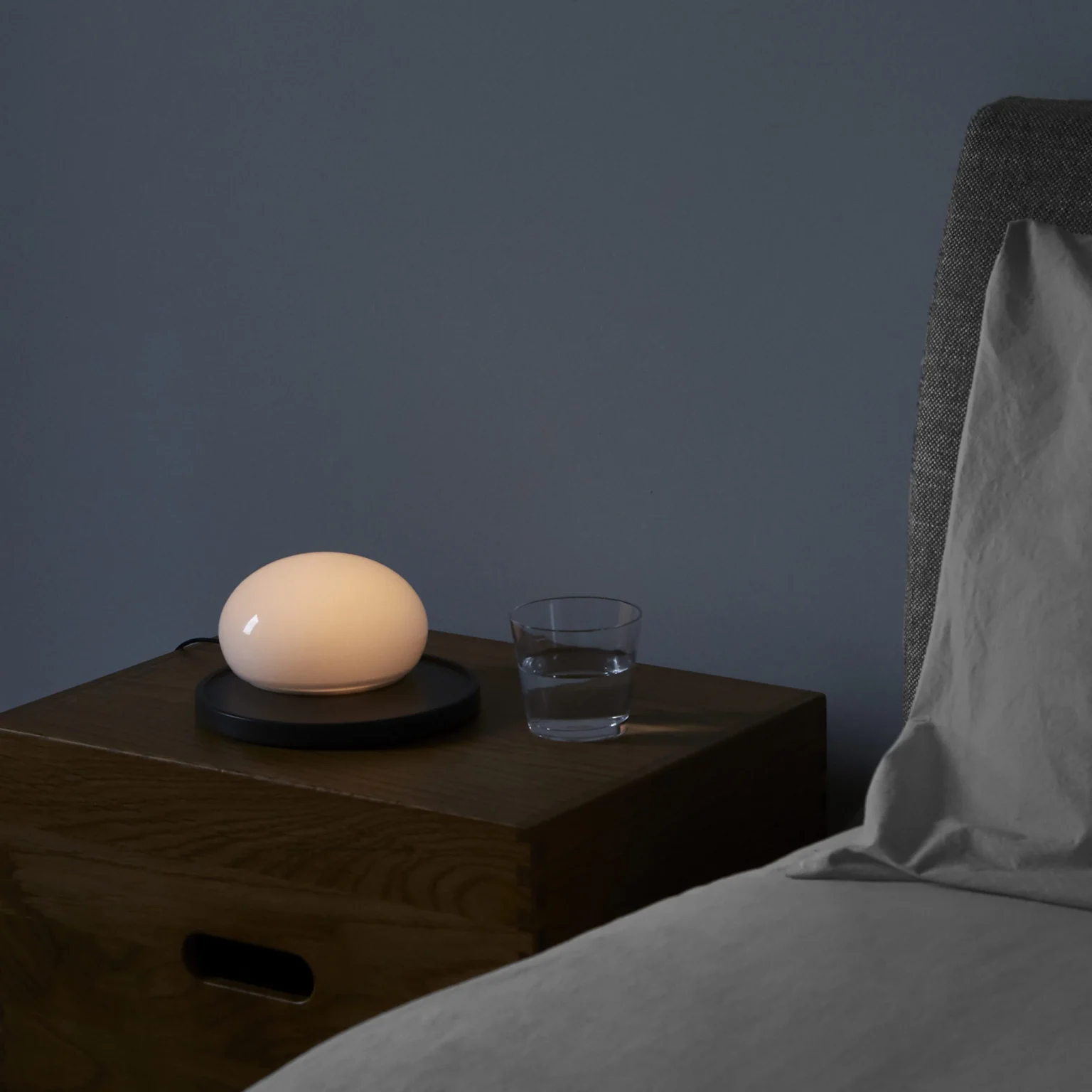 “Modern bedside lamp Bolita by Marset – sleek and tactile lighting with curved glass design”