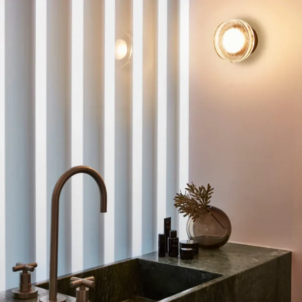 “Roc by Marset minimalist wall lamp – textured ceramic surface casting ambient light upward and downward”