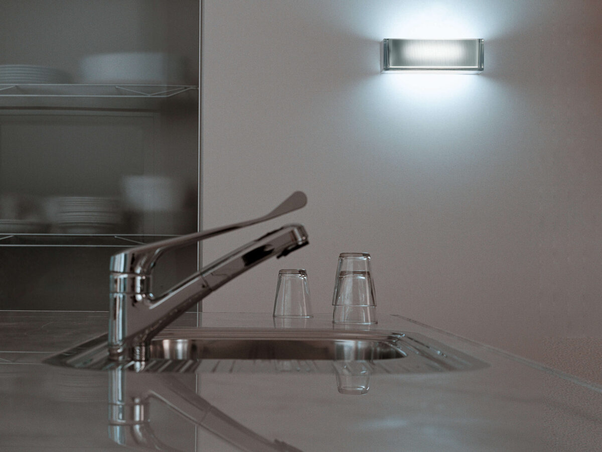 The Flos Ontherocks HL, a sophisticated wall sconce designed to emphasize the quality of light, with its clear glass body and an internal opal glass element for diffused illumination.