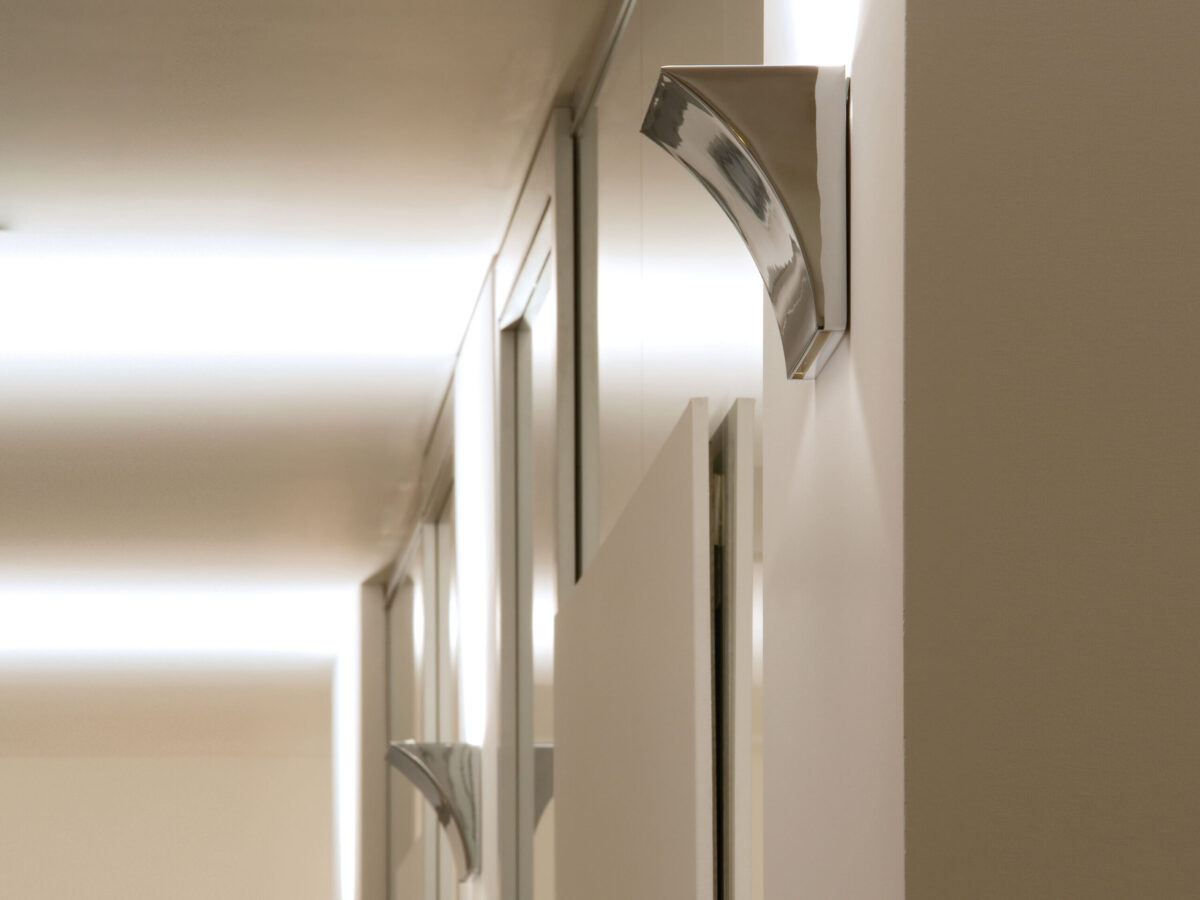 The elegant Flos Pochette Up/Down LED by Rodolfo Dordoni, a sleek, rectangular wall-mounted fixture with a pressure die-cast Zamak alloy body, providing direct and indirect light.