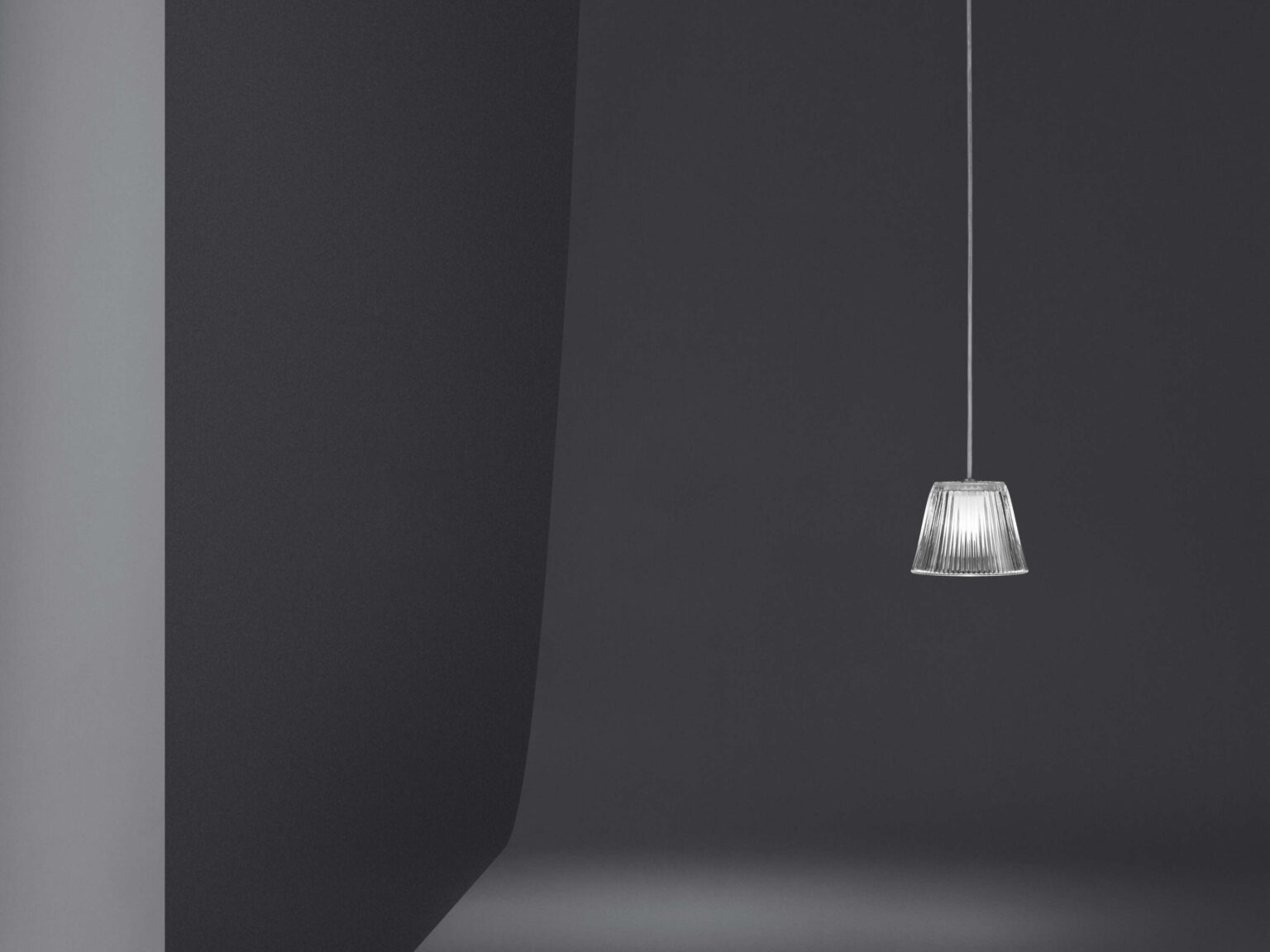 Round Romeo Babe Suspension lamp suspended by long clear cord, softly diffusing light through acid-etched borosilicate glass.