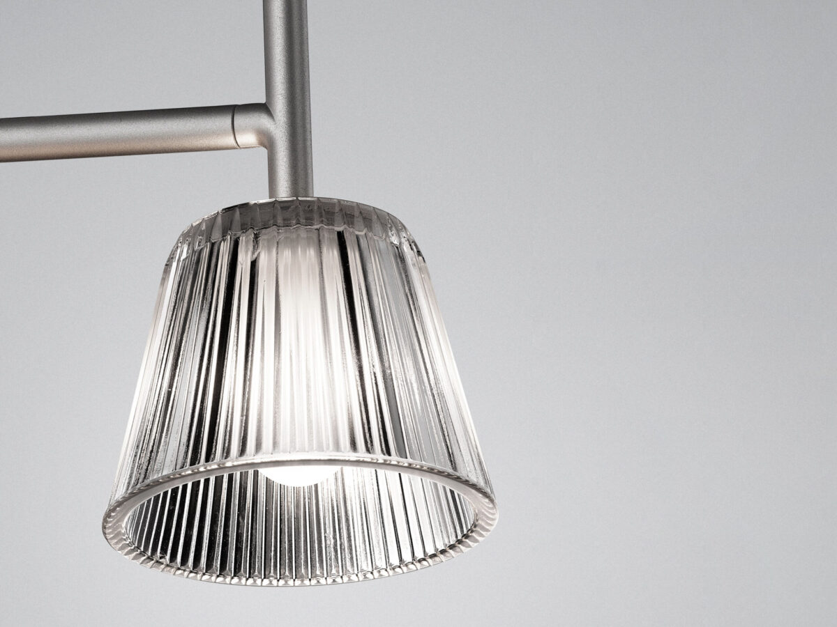 The elegant Flos Romeo Babe Wall by Philippe Starck, a wall-mounted fixture featuring a classic shade shape and a gray painted die-cast aluminum arm, designed for ambient illumination.