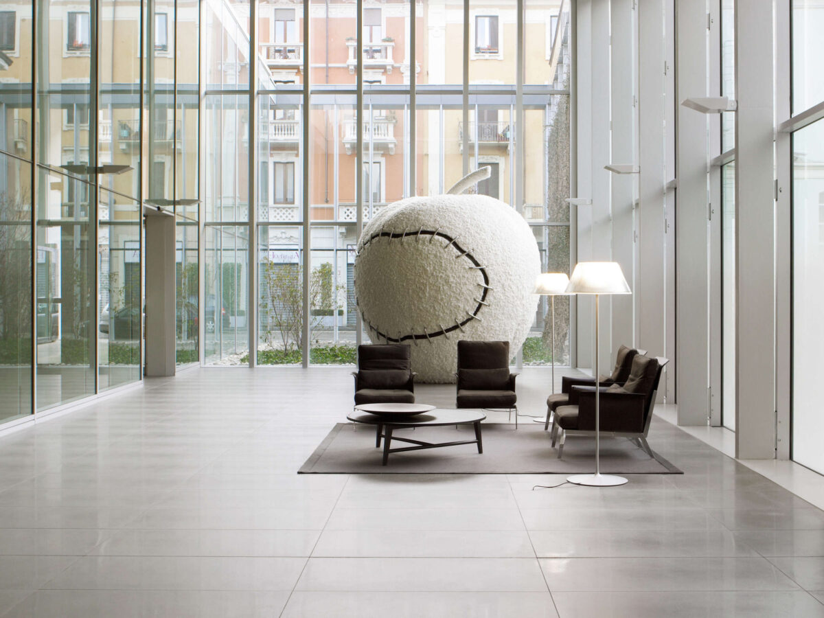 Tall Romeo Moon Floor lamp casting warm ambient light through fluted glass shade over reading nook