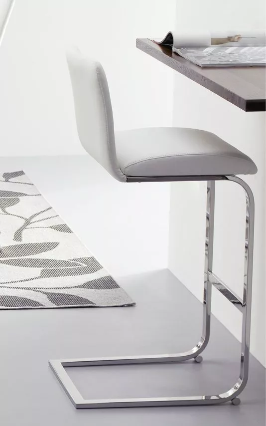Lisa Fix bar stool by Peressini with light grey upholstered seat and back pad suspended on a cantilever chrome base, shown beside a modern kitchen island.