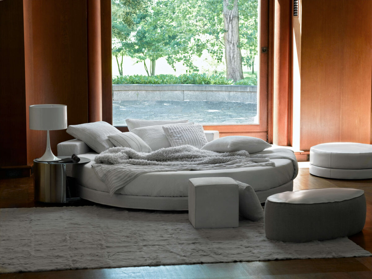 Side view of the Spun Light Table 1 by Flos in black, radiating soft diffused light over a minimalist desk.