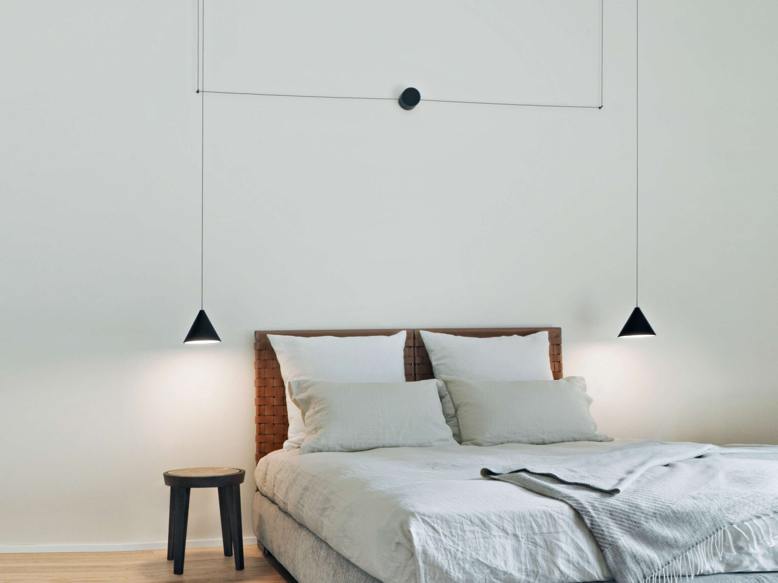 Cone-shaped LED pendant with opal polycarbonate diffuser, delivering warm 2700 K illumination in a chic workspace.