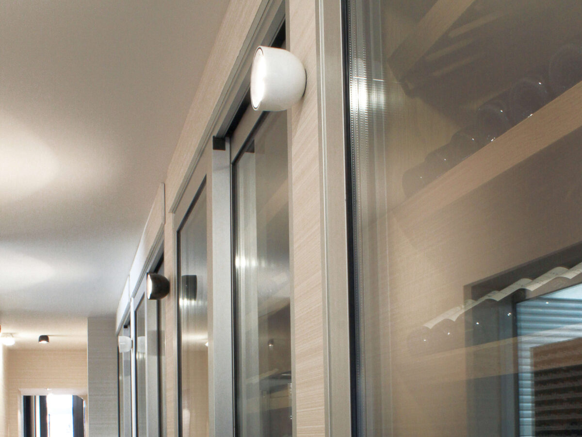 A contemporary Flos Wan Ceiling/Wall lamp, showcasing its unique design with a recessed light source and a safety tempered glass disc, ensuring comfortable, direct light.