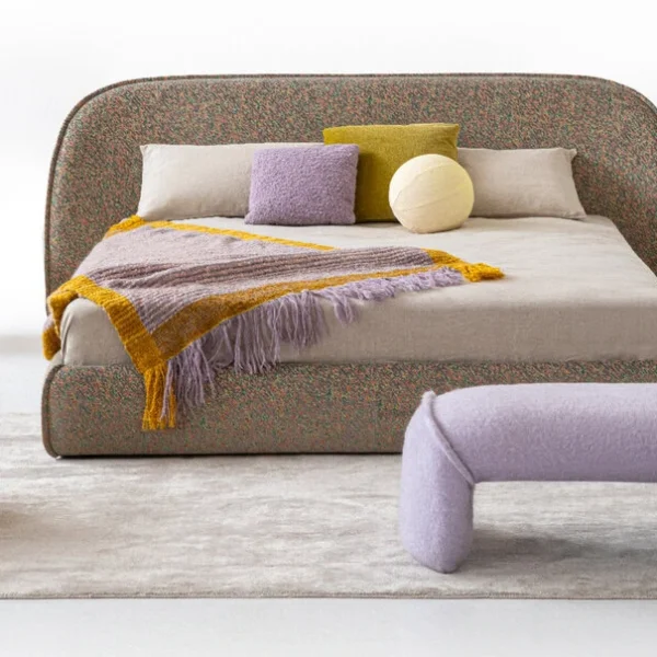 Sedona bed in muted lilac upholstery with rounded headboard and matching base, styled in a warm desert‑inspired bedroom