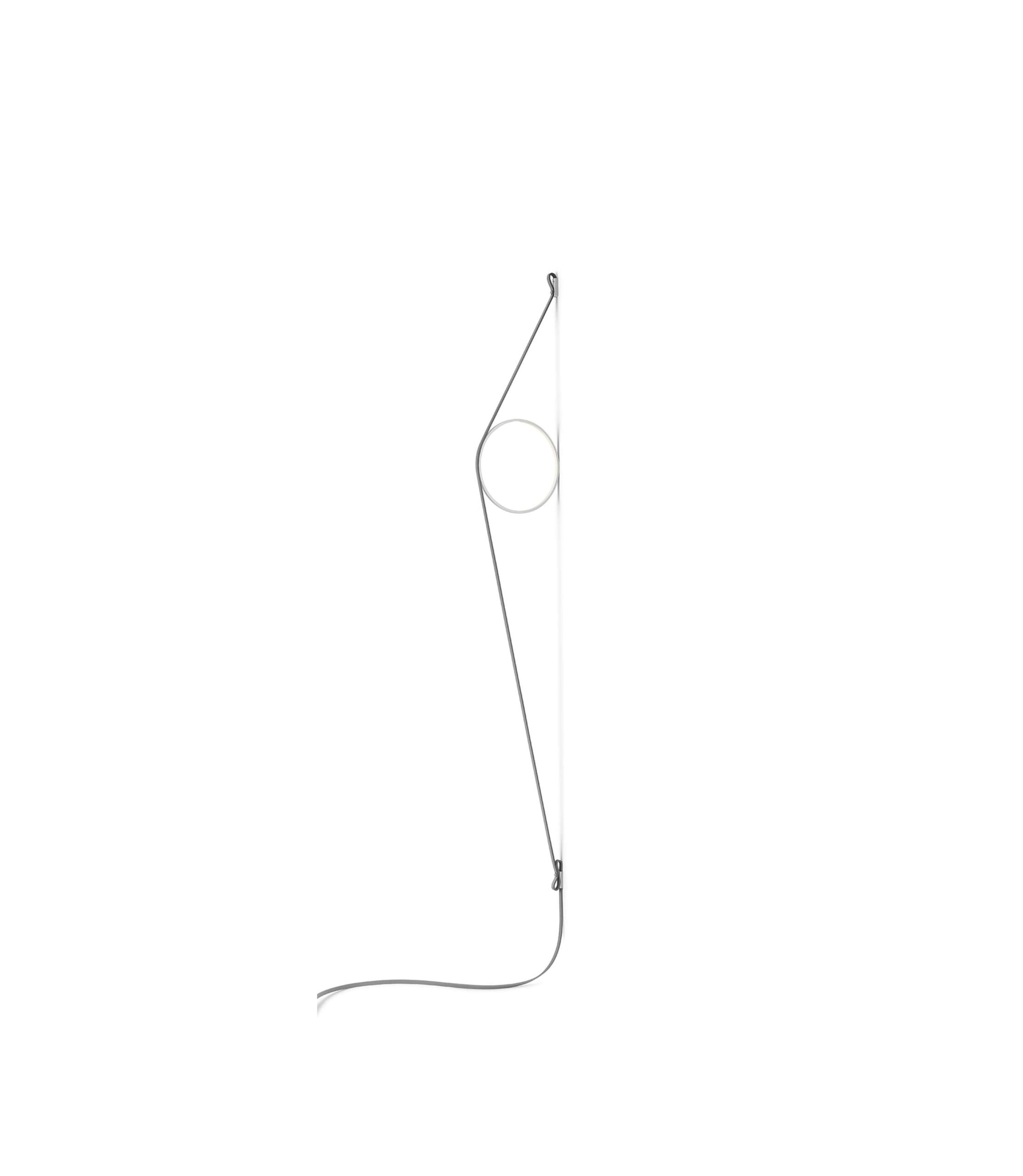 A modern Flos Wirering wall lamp featuring a large, grey rubber power cable tautly stretched to support a circular, LED-illuminated grey aluminum ring, creating indirect light.