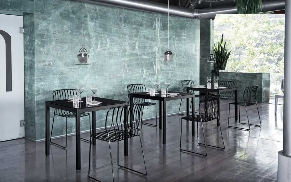Modern Sharp table with glossy white SuperCeramic surface and slim sand-finished steel frame in a bright contemporary room.
