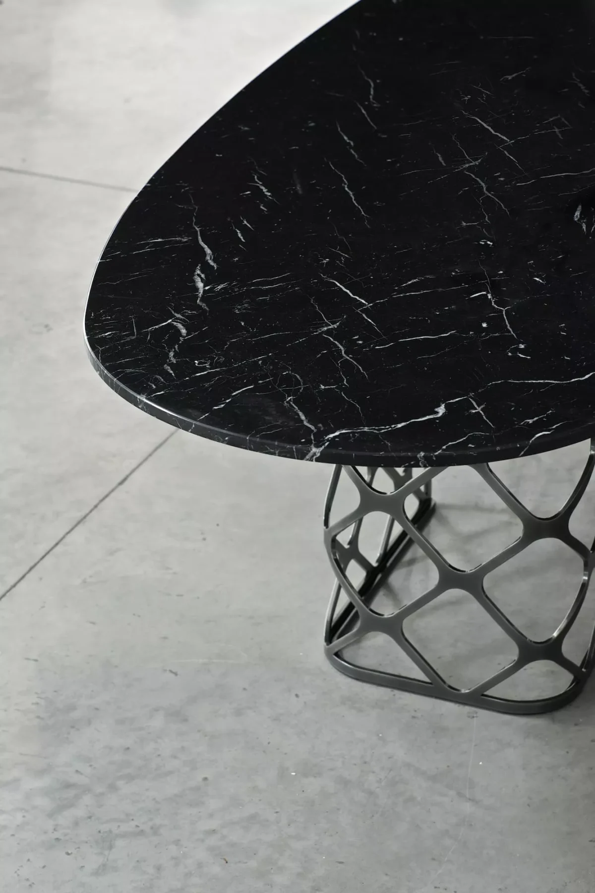Majesty fixed table by Bontempi with glossy anthracite SuperCeramic top and matte black perforated steel supports in a modern dining room.