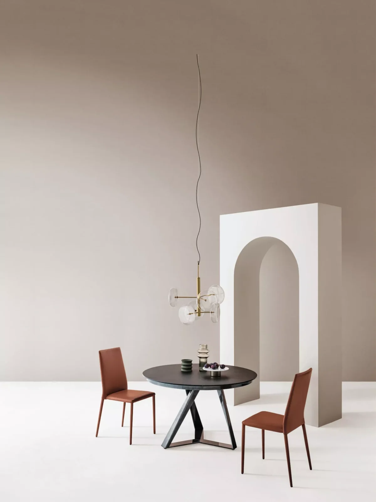 Millennium Round by Bontempi – round fixed table with walnut veneer top and multi‑color lacquered metal base in a modern dining room.