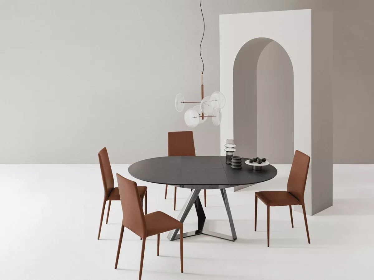 Close‑up of Millennium Round by Bontempi highlighting the sculptural metal frame in natural‑silver lacquer supporting a SuperCeramic tabletop.