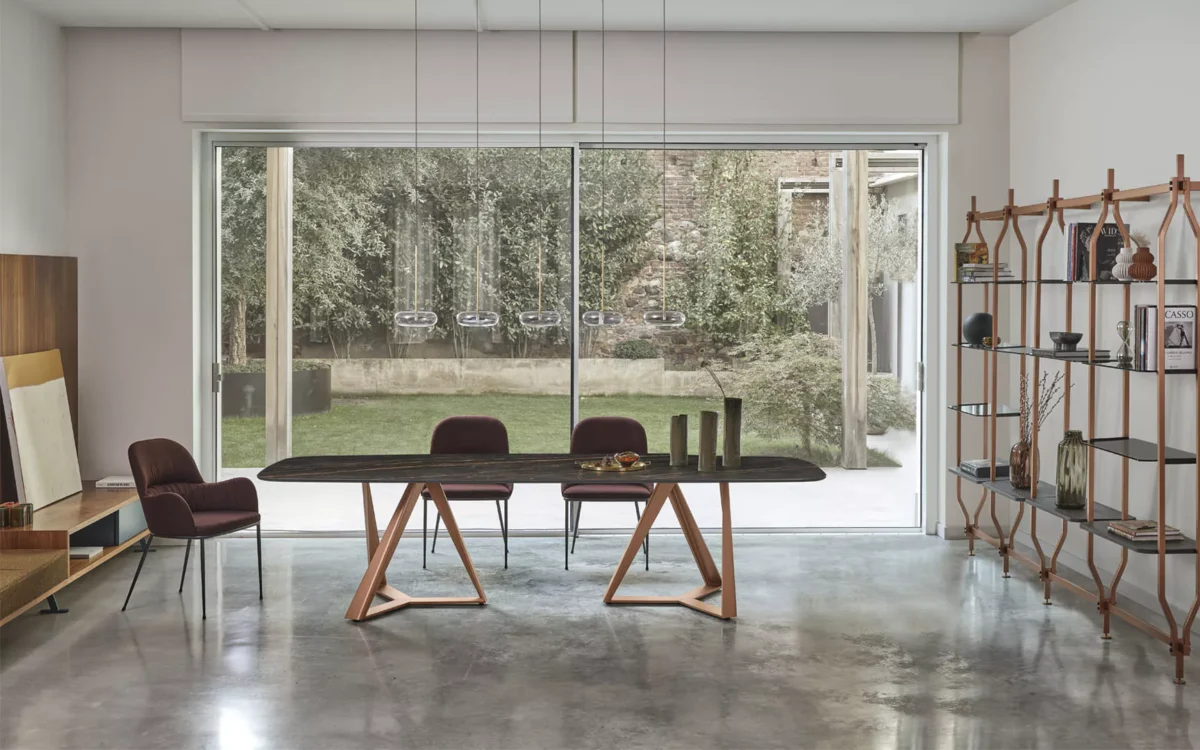Millennium XXL table by Bontempi with glossy Arabescato SuperMarble top and natural‑silver lacquered double trestle legs in an executive dining room.