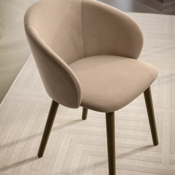 "Stylish Rebecca chair with organic curves, available in multiple upholstery colors and wood or metal frames."
