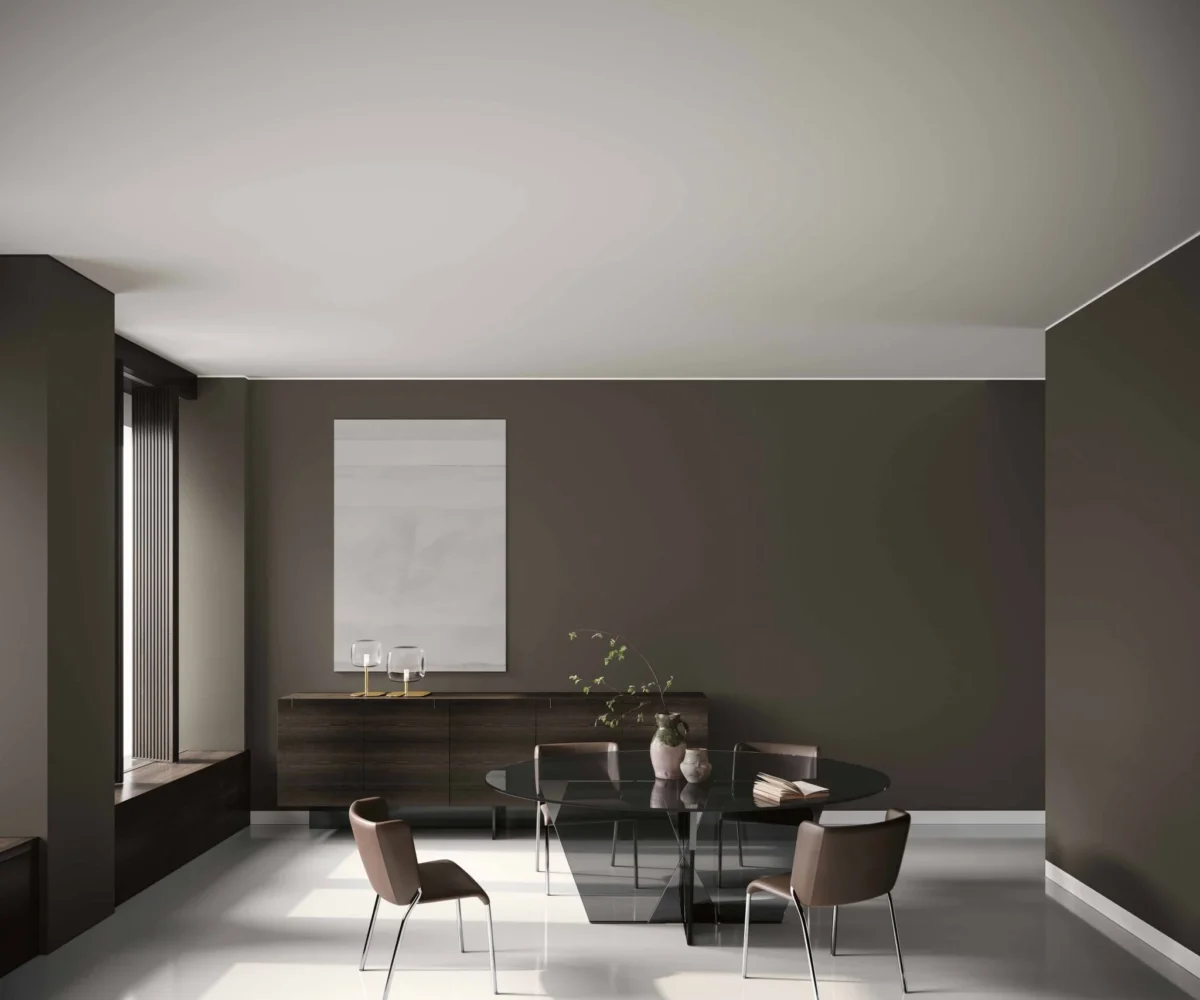 Crossover dining table by Tonelli Design with extra-clear glass top and pyramidal metal joint in polished gunmetal finish, displayed in Royal Oak, Michigan.