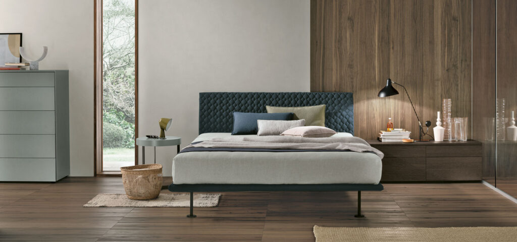 “Tomasella Seven – refined upholstered bed featuring soft fabric finish and modular headboard design”
