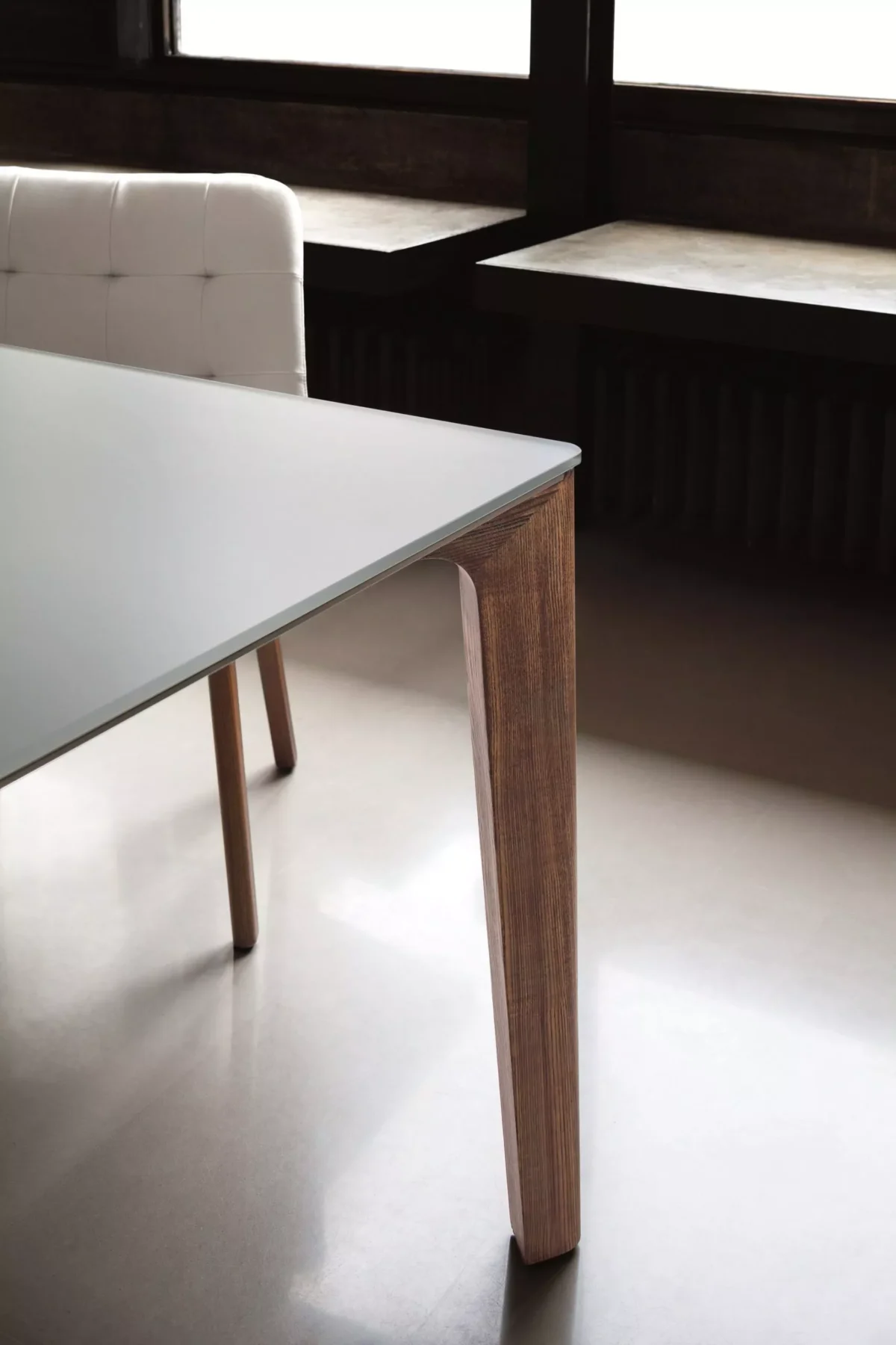 Long rectangular Versus by Bontempi in Savoia grey SuperCeramic top with natural oak legs, suited for open-plan kitchens.