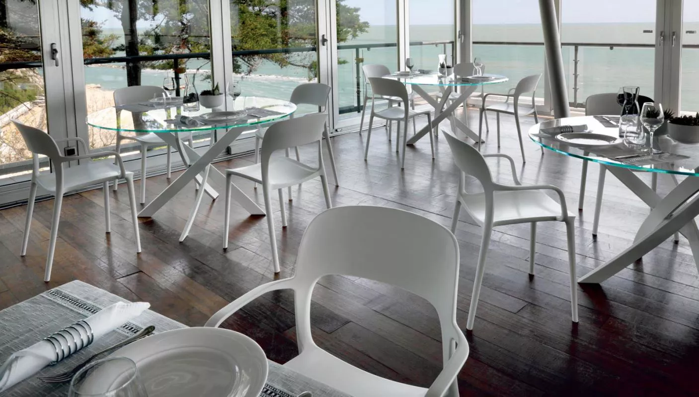 Minimalist interior featuring Barone by Bontempi with smoky‑grey glossy glass top and white lacquered crossed base.