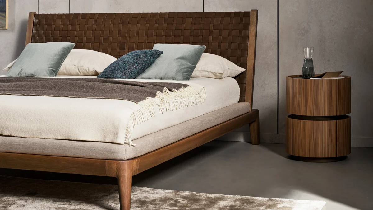 Elegant Moneypenny nightstand by Bonaldo, featuring a curved wooden cylinder with a matte lacquered wood base in bronze or lead finish.
