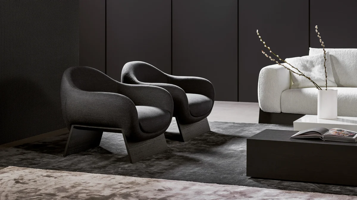 Contemporary Bonaldo Boolean armchair showcasing soft curvy profile atop solid wood bridge base in Canaletto walnut