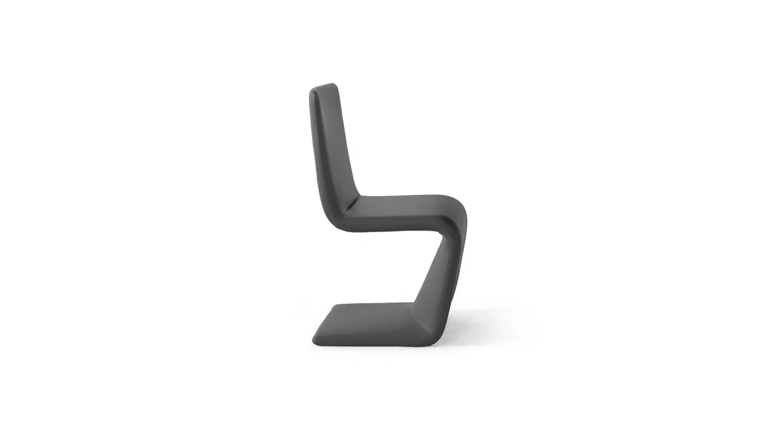 "Venus chair in deep green fabric with black legs, adding a bold accent to a contemporary space."