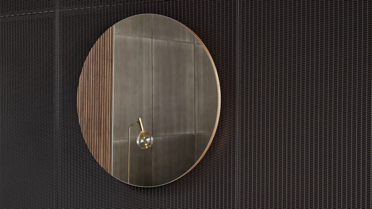 Bonaldo Musa round mirror with one-third ribbed walnut edge juxtaposed against clean mirrored glass