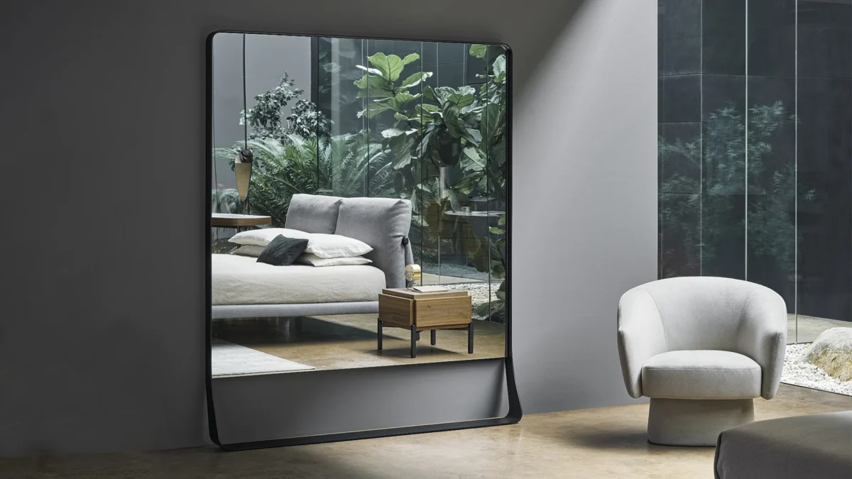 Bonaldo Narciso mirror featuring tall rectangular form, wide metal base creating floating visual effect
