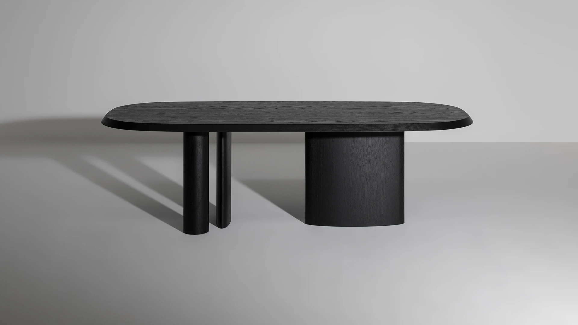 Bonaldo Padiglioni table with asymmetrical three‑leg wood base and rounded Canaletto walnut tabletop