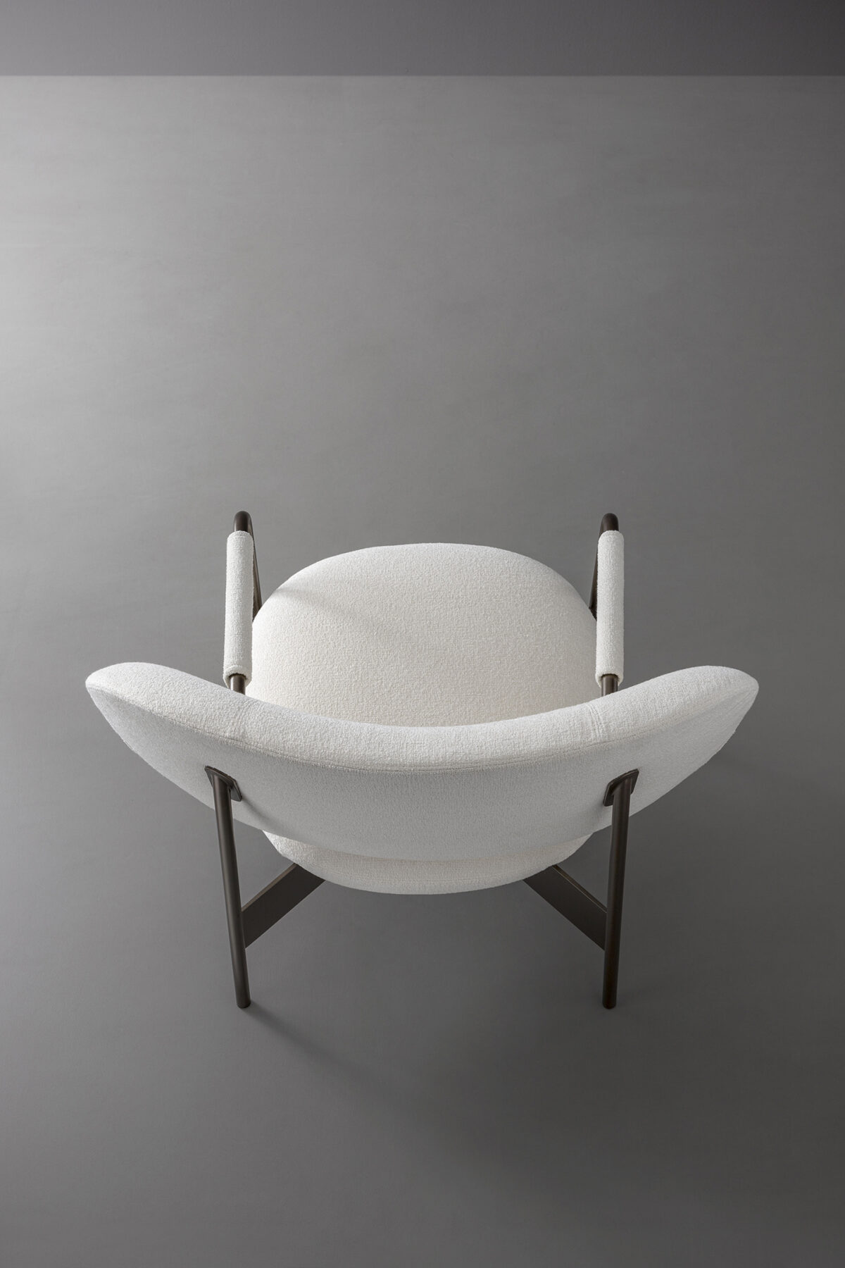 Bonaldo Cross Lounge Chair in fabric upholstery with graphic metal X‑base and single‑tube armrest design.