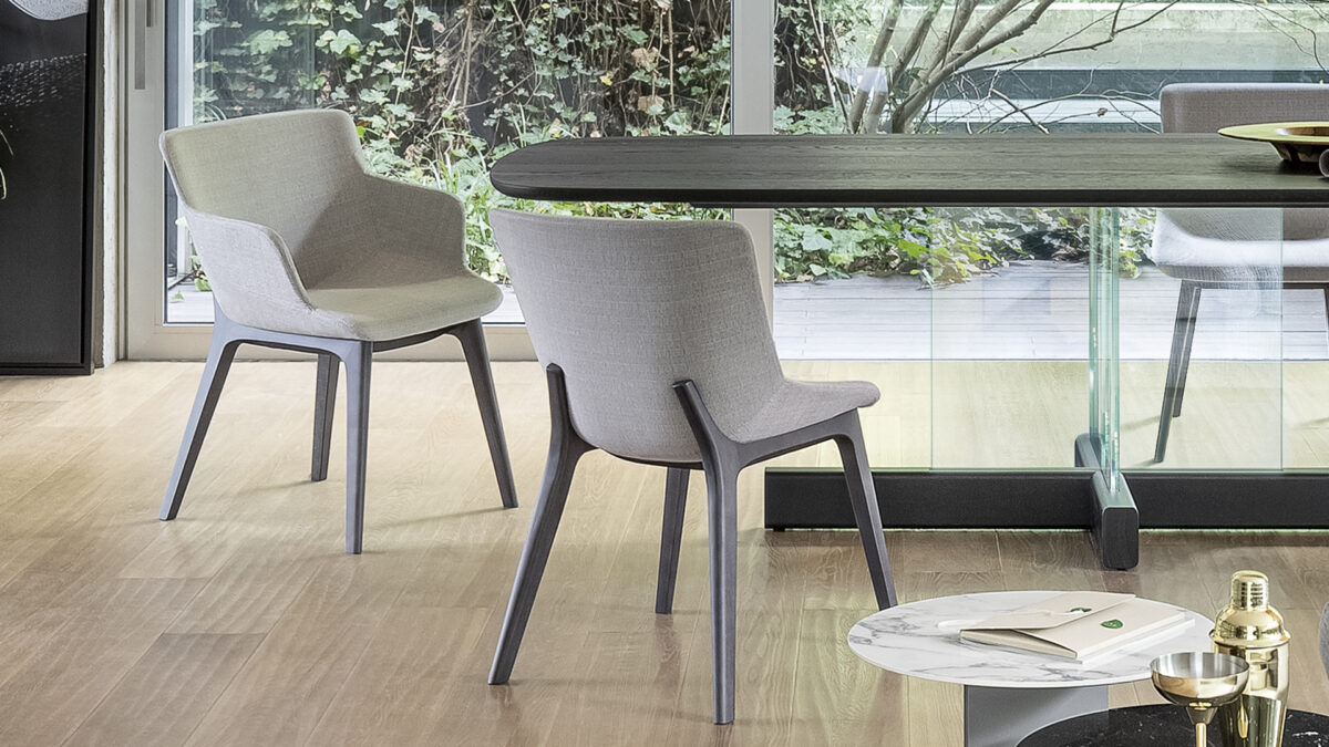 "Miss Artika armchair variant featuring wider seat and armrests, upholstered in fabric with sled base."