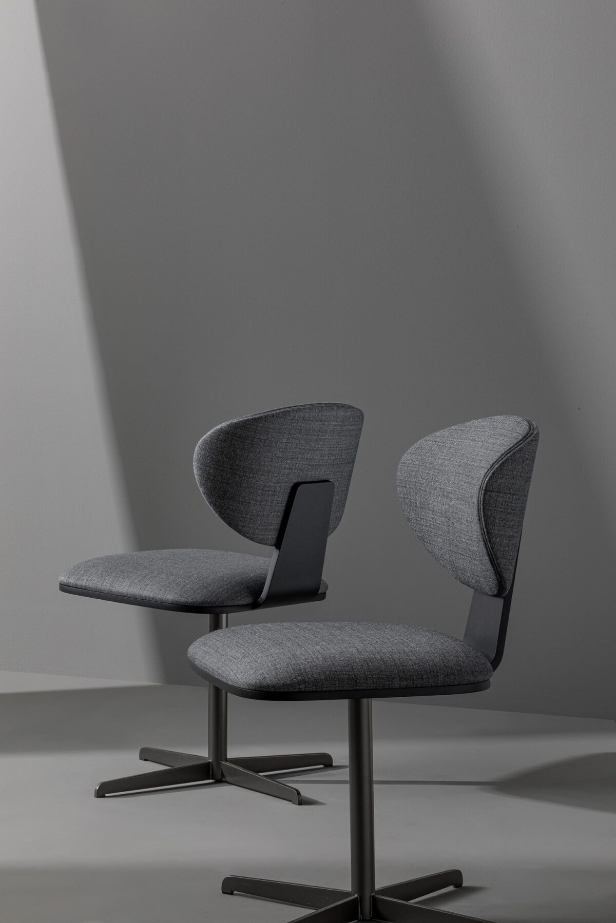 "Olos Office Chair with a matte black metal base and upholstered seat in Baia Fabric SP52."
