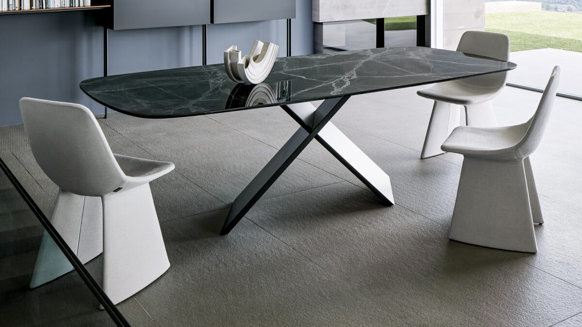 "Modern Agea dining chair in dark eco‑leather, featuring monolithic angled legs and a fully upholstered shell."