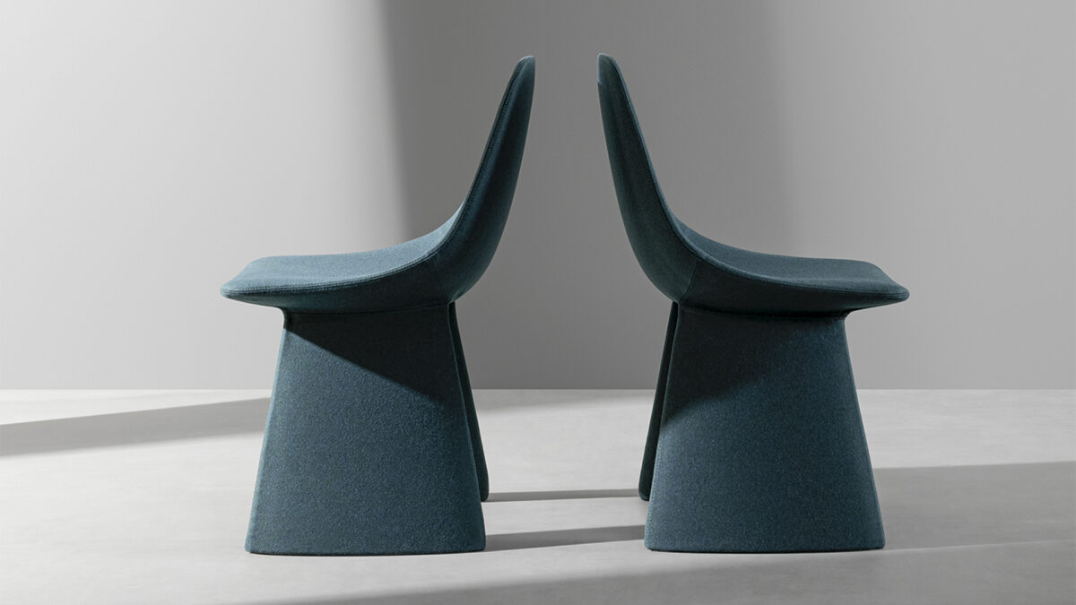 "Agea chair by Bonaldo upholstered in sage‑green fabric, with bold sculptural legs appearing as twin buttresses supporting a curved seat."