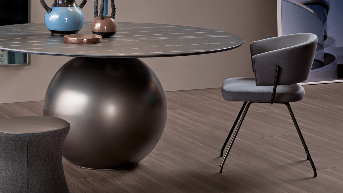 "Bahia chair in fabric upholstery with bronze-painted metal legs, designed for contemporary interiors."