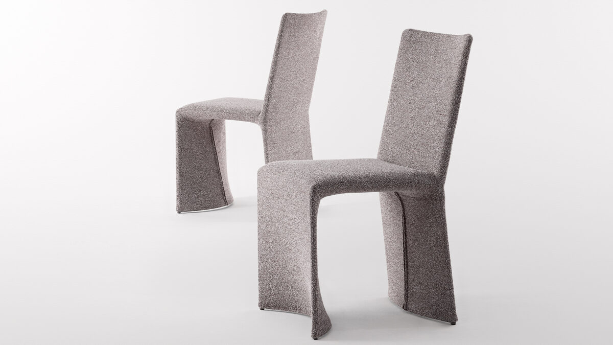 "Angled view of Miss Ketch chair showing wraparound arms and slim metal frame."