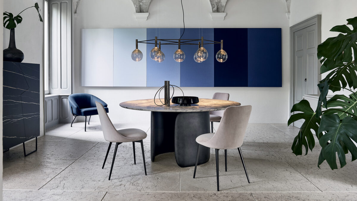 "Mellow dining table by Bonaldo with two curved polyurethane base modules embracing each other beneath a rounded-edge tabletop."