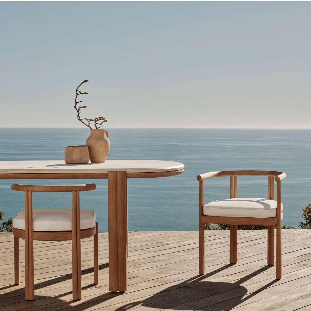 “Harbour Cove teak outdoor dining table – pill-shaped design in warm natural finish”