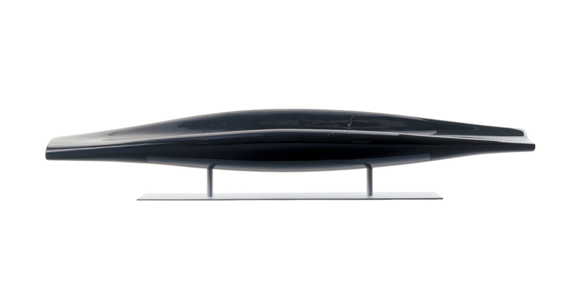 “Three-quarter shot of InOut paddle‑shaped bench upholstered in deep red lacquered fiberglass on a sleek metal pedestal.”