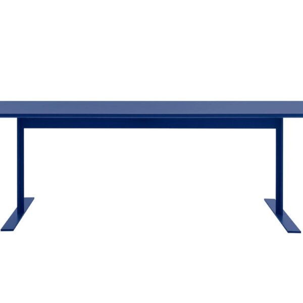 “Detail image of white-lacquer Luxor Table’s metal feet and wood-fibre top in an airy contract space.”