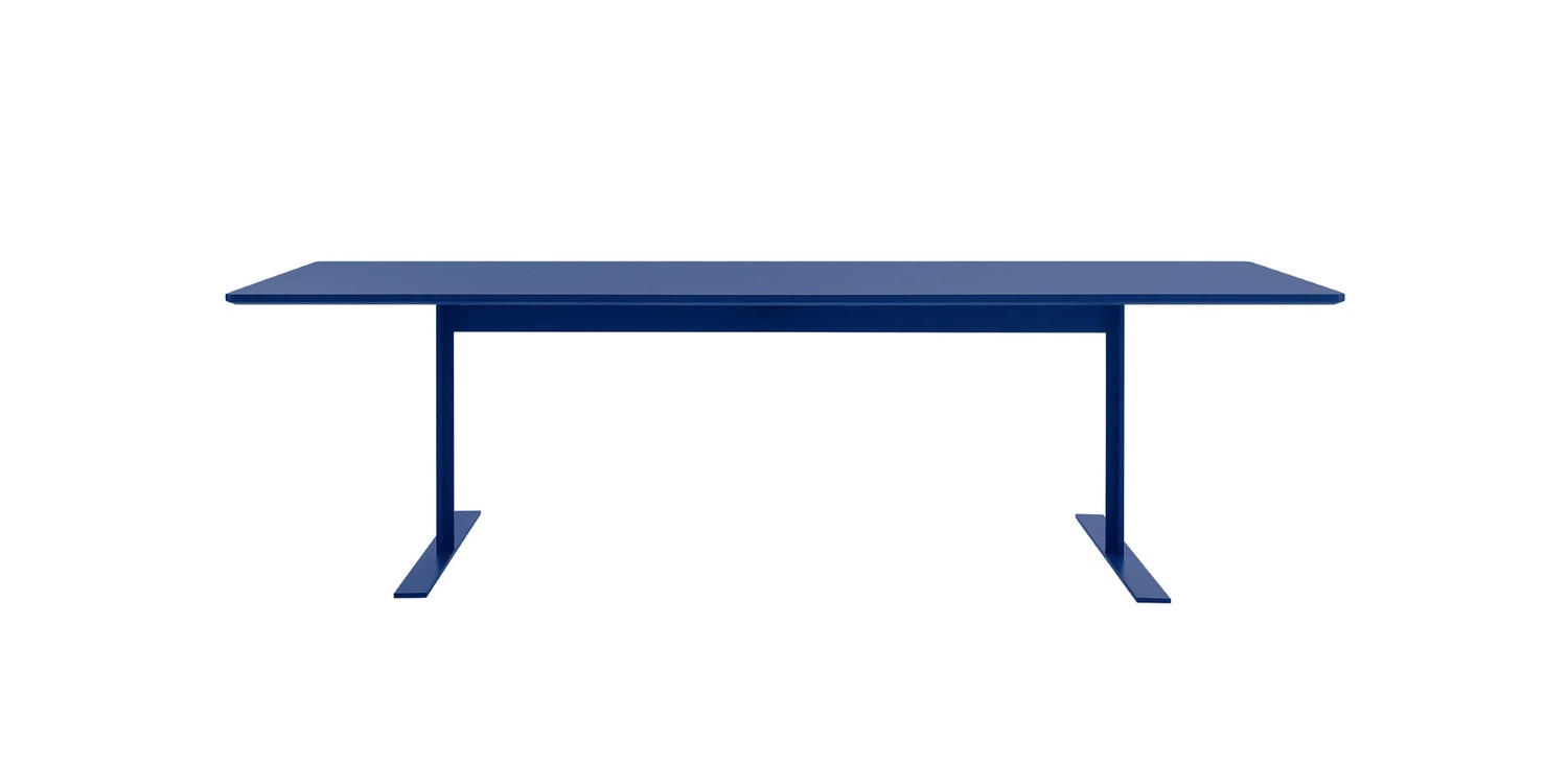 “Detail image of white-lacquer Luxor Table’s metal feet and wood-fibre top in an airy contract space.”