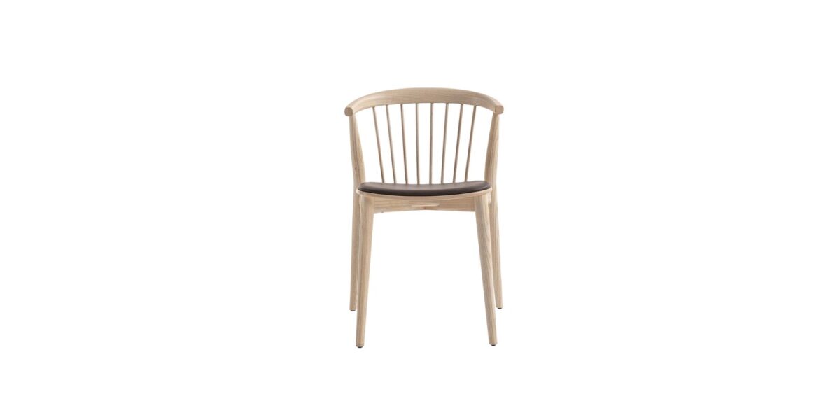 "Detail shot of the smooth bend where the curved backrest meets the seat on the Newood wooden chair."