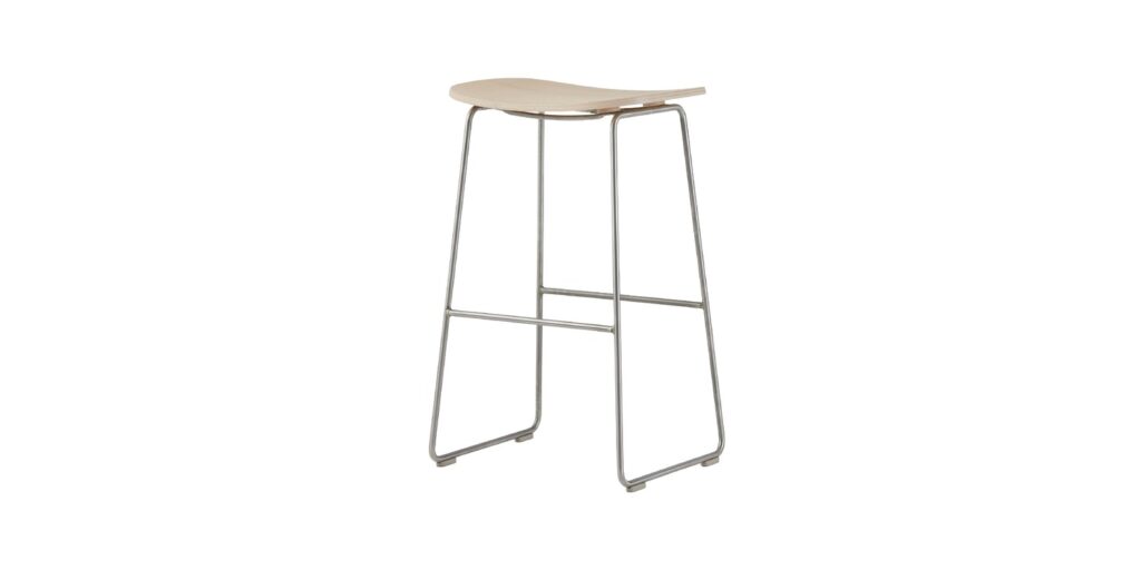 “Detail shot of footrest support brace and polypropylene foot caps beneath a high Morrison Stool.”