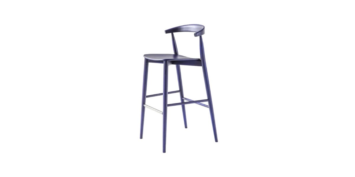 “Detail close-up showing the junction of the plywood seat and ash frame, with stainless steel footrest, on a black-stained stool.”