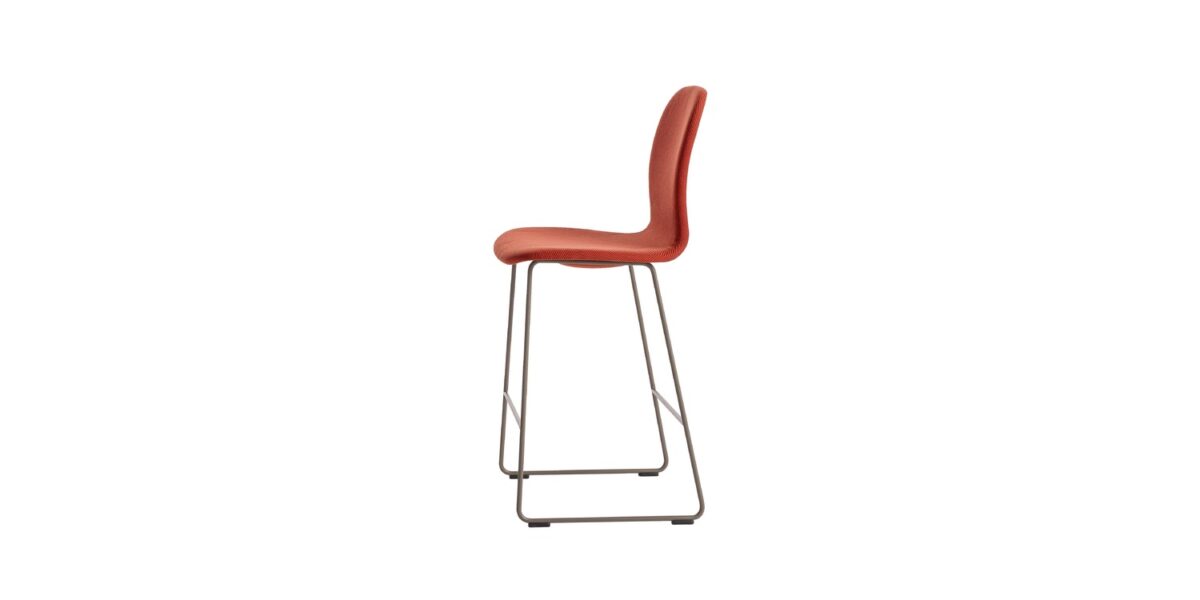 “Low-height stool with beige leather upholstery on a matte-mud sled base, featured in a contemporary office lounge.”