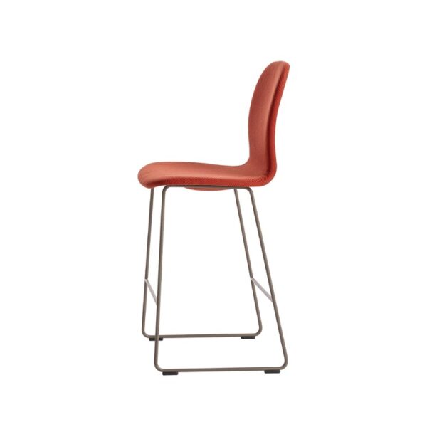 “Low-height stool with beige leather upholstery on a matte-mud sled base, featured in a contemporary office lounge.”