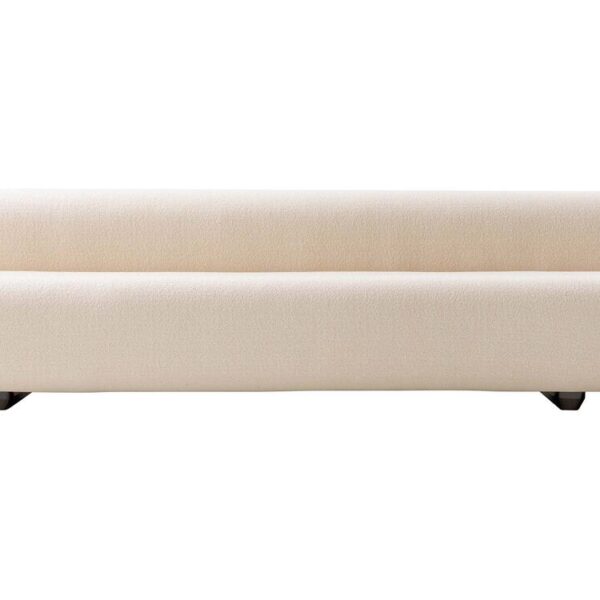 “Three-quarter view of Big Sofa under pergola, its plush upholstery contrasting with polished chrome legs in an outdoor-adjacent lounge setting.”